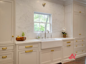 White marble kitchen sink area with marble backsplash.